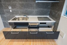 充実のキッチン設備。引出式カウンター。 3口コンロ(IH)。タイル仕上キッチン前面。